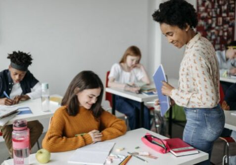 Teacher walking the aisles observing students doing their class work | Hadinger Flooring