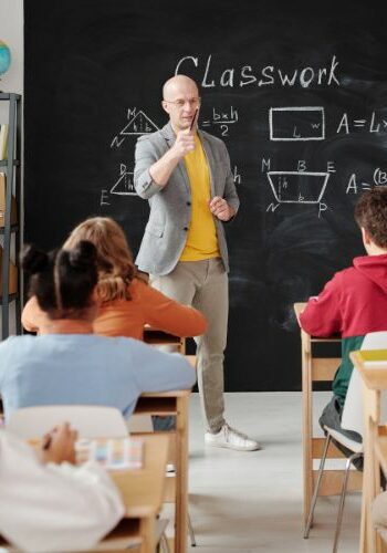 Teacher standing at chalboard in front of classroom | Hadinger Flooring